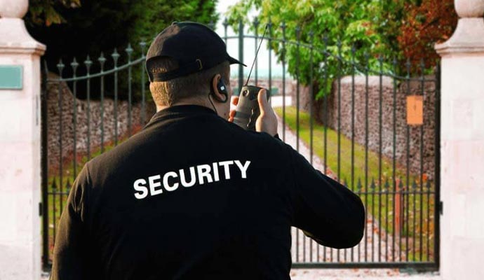 A back-view of a security guard in a black uniform