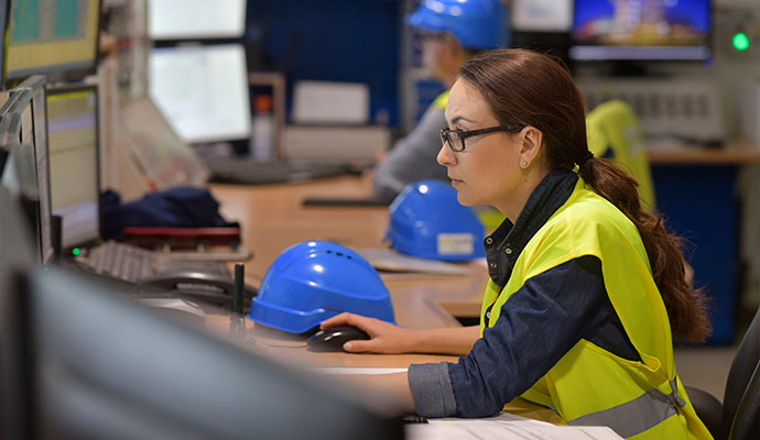 Construction site operations staff monitoring security and project systems from industrial control center