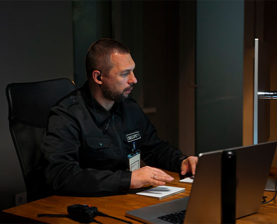 Security professional monitoring surveillance systems and managing operations from security control center