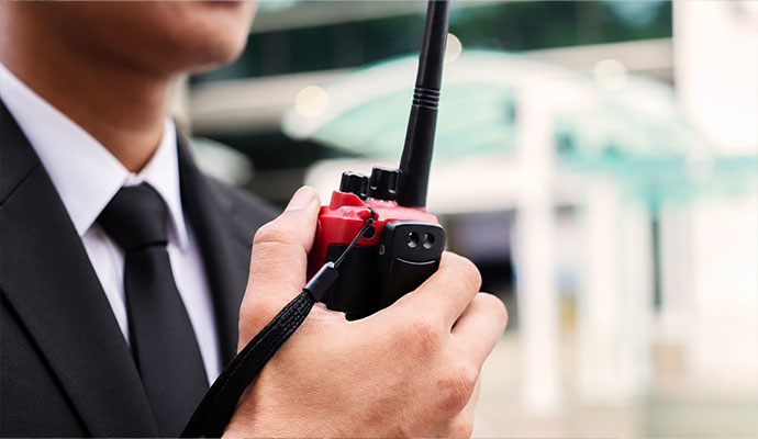 Security officer holding two-way radio for mobile patrol service