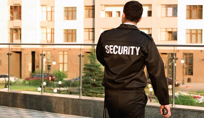 Security officer conducting residential property patrol outside apartment community buildings