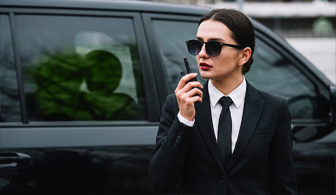 Security guard with walkie-talkie beside SUV