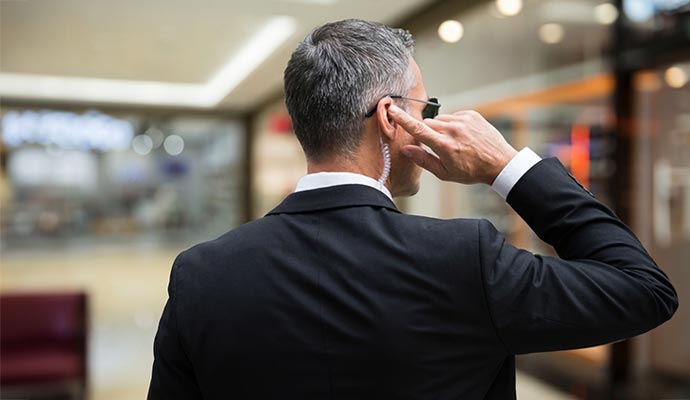 Security officer adjusting earpiece in lobby