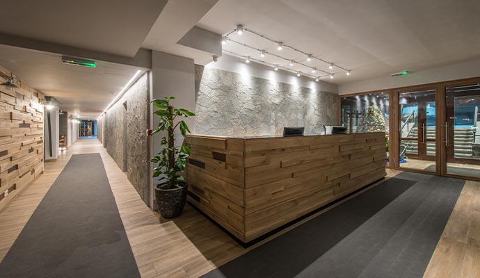 A hotel lobby reception desk with wooden paneling