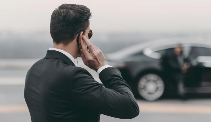 Executive protection officer with earpiece and vehicle