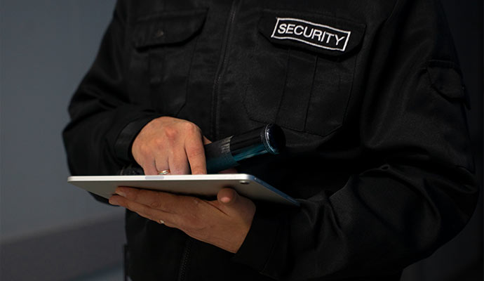 Modern security professional monitoring with digital device
