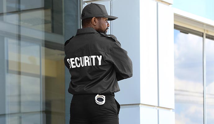 Security guard standing outside commercial building