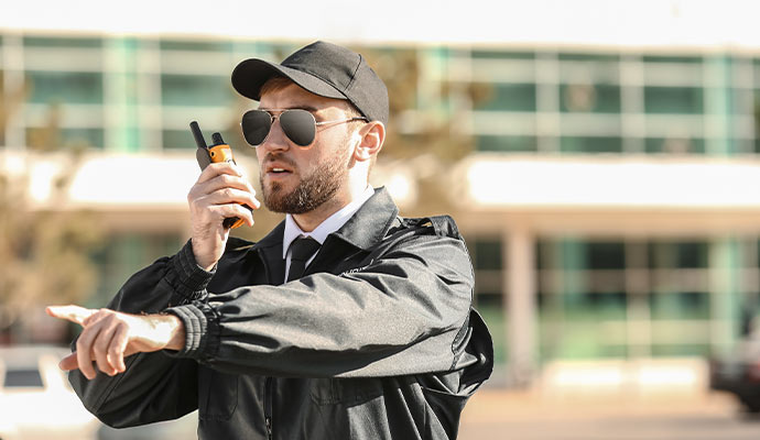 Security officer giving instructions with yellow walkie talkie