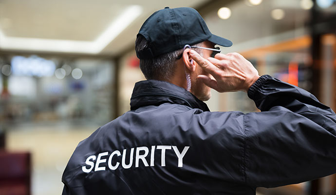 Security person communicating through earpiece in indoor facility