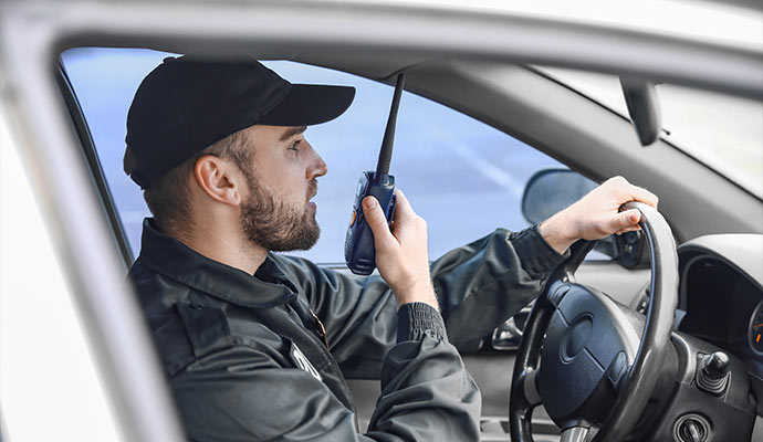 Security person in uniform communicating with walkie talkie