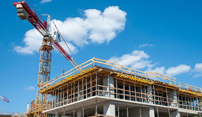 A tower crane working on a commercial building construction site