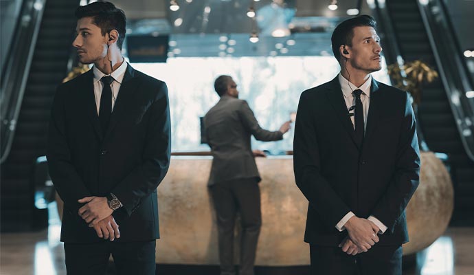 Two bodyguards standing in building lobby